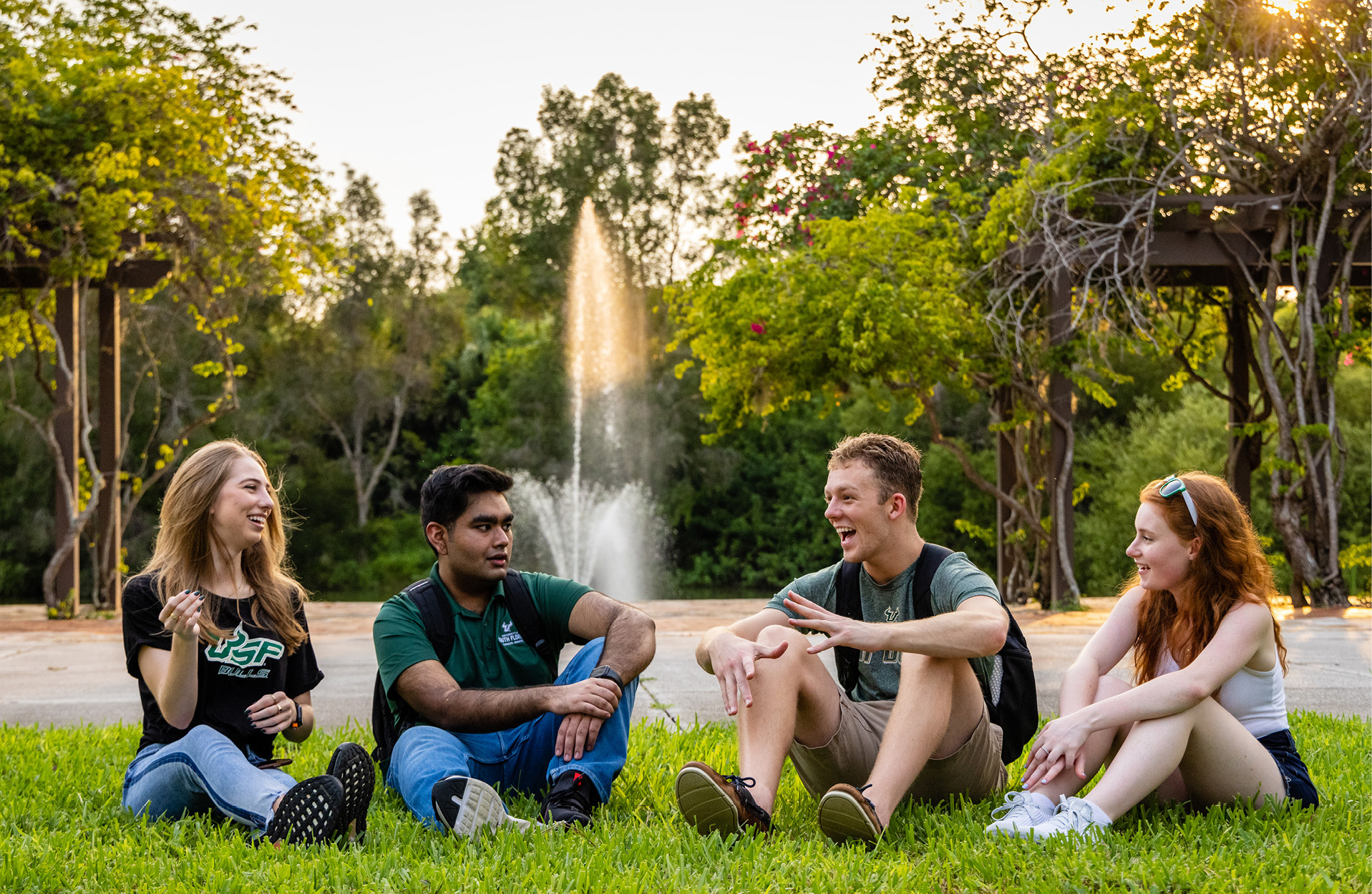 Four students relax on the lawn at USF Sarasota-Manatee