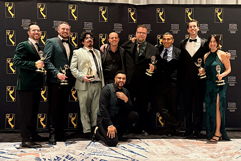team members from ined studios stand and pose with emmy trophies