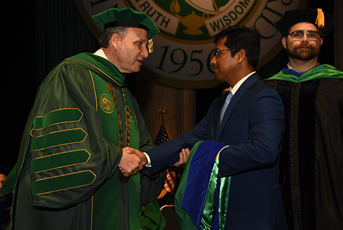 A representative of the Consulate General of Bangladesh, Miami accepts the postumous degrees
