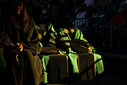 Two empty chairs with doctoral regalia