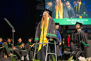 Student walks across stage at commencement