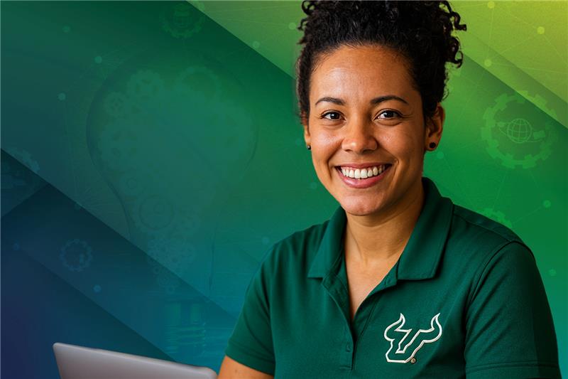 a woman sits on a laptop smiling at camera