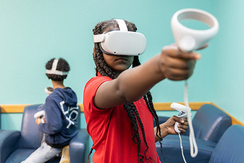 Child using VR head and hand set